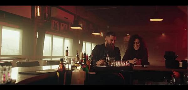  man and woman kissing sitting in bar with pink lights